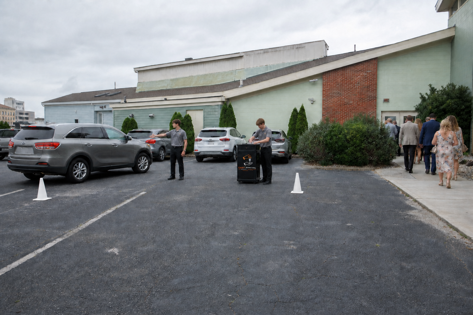 Valet attendants directing vehicles in a Hampton Roads asphalt event lot